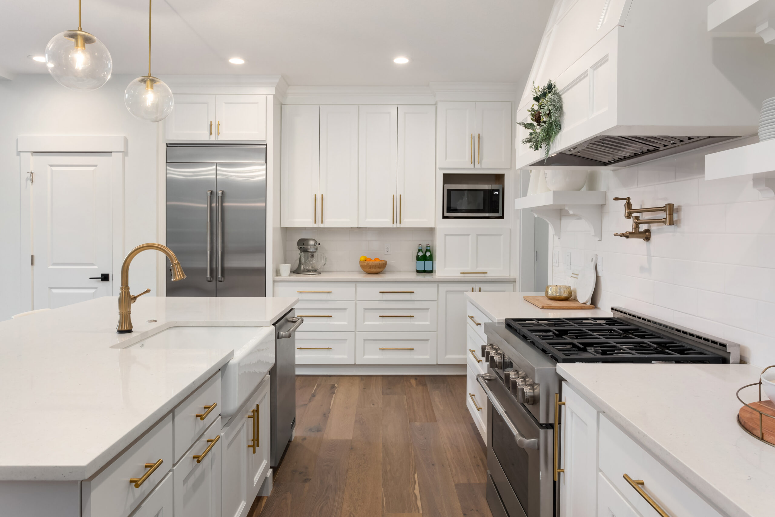 beautiful kitchen in new luxury home with island, pendant lights, and hardwood floors